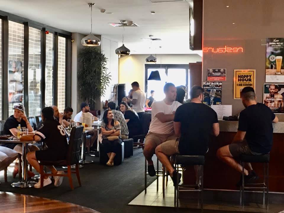 Fully booked restaurant with happy customers enjoying their meals